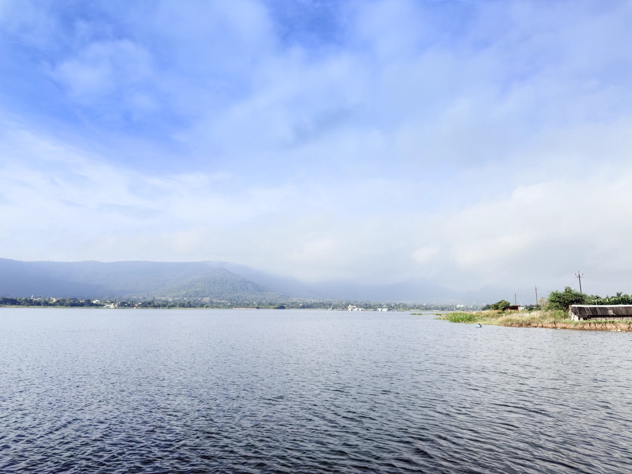 Photograph of Kasarsai dam with the Shayadris in the background, shrouded by the retreating monsoon clouds