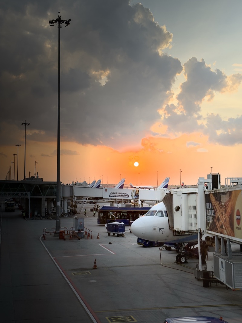 The Four Body Problem - Sunset at Bengluru T1 Airport; iPhone lens and glass of the jet bridge causing the sun to appear four times in this shot.